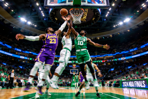 2024年NBA总决赛现场，洛杉矶湖人队与波士顿凯尔特人队球员在篮下激烈争抢